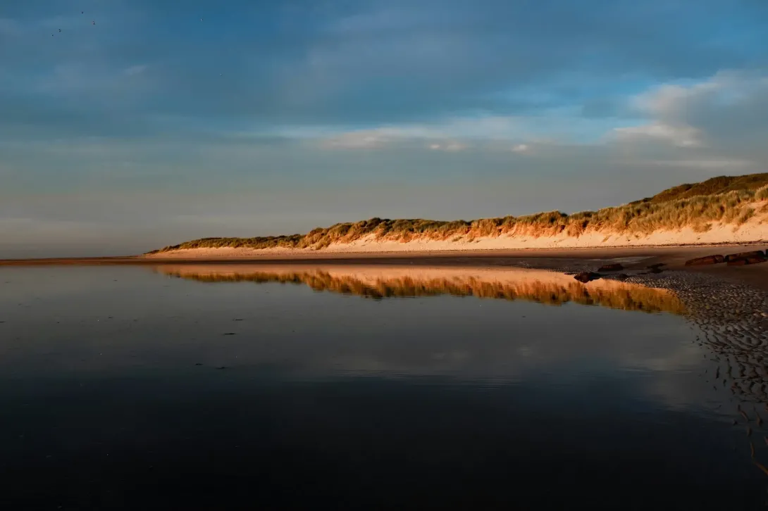 Body of water with a hill in the distance