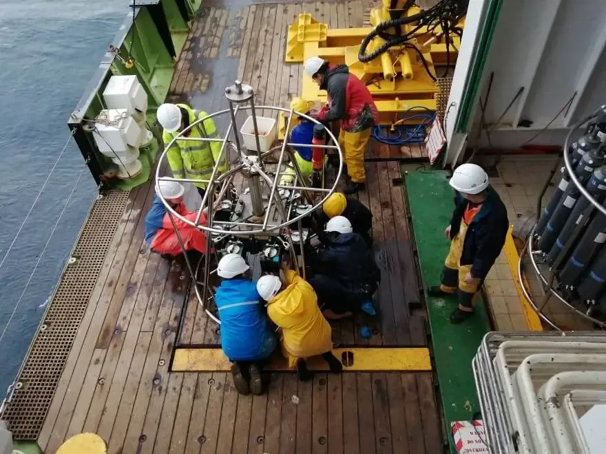 Retrieving sediment cores from an early-morning Megacorer recovery.